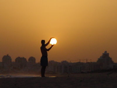 Person seeming to hold the setting sun in their hands